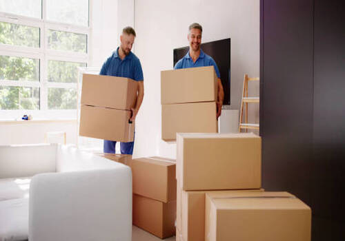 Movers Delivering Packaging Boxes. Moving And Relocation Movers Delivering Packaging Boxes. Moving And Relocation